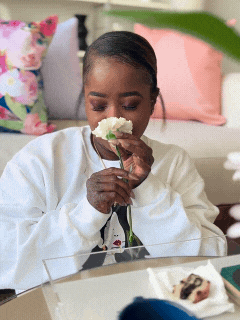 woman smelling a flower at photo shoot for home decor